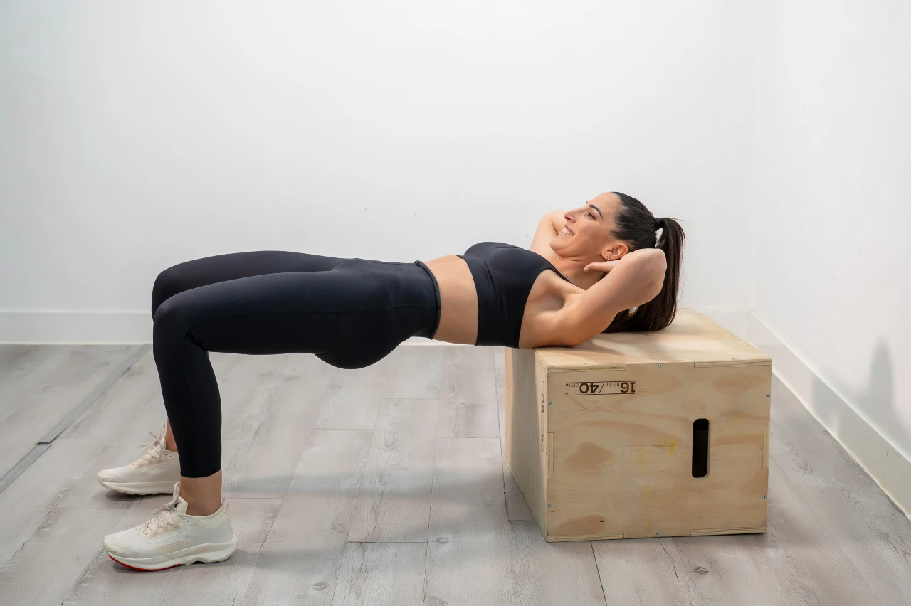 Bei den Hip Thrusts ist eine saubere Technik das A und O. Frau trainiert Hip Thrusts mit Plyo Box