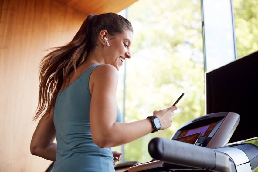 Frau-Laufband-Konnektivitaet-mit-Handy