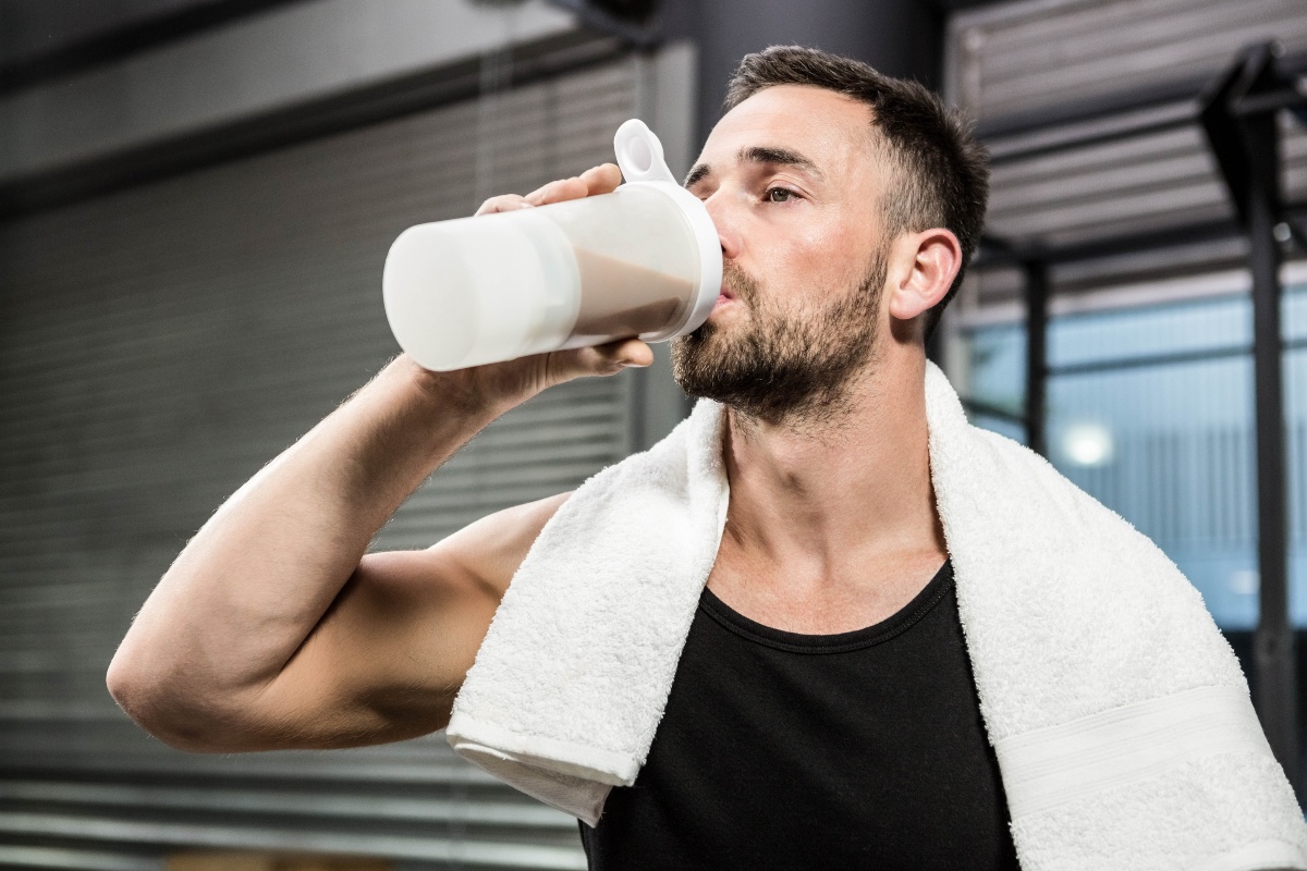 Wer zielgerichtet trainiert, sollte auch die Ernährung dementsprechend optimieren Mann im Gym trinkt Protein Drink - Hypertrophie-Training